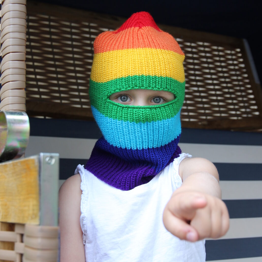 Kind mit Sturmhaube in Regenbogenfarben
