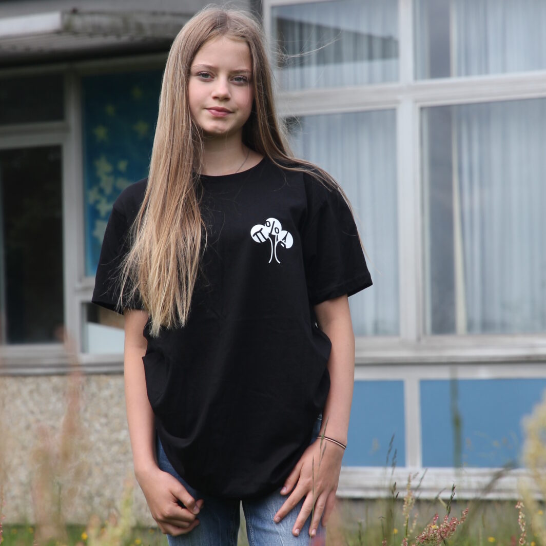 Schülerin mit T-Shirt bedruckt mit Schullogo