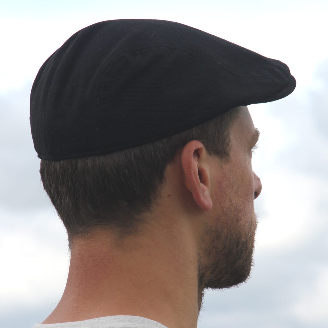 Mann mit schwarzer Schiebermütze