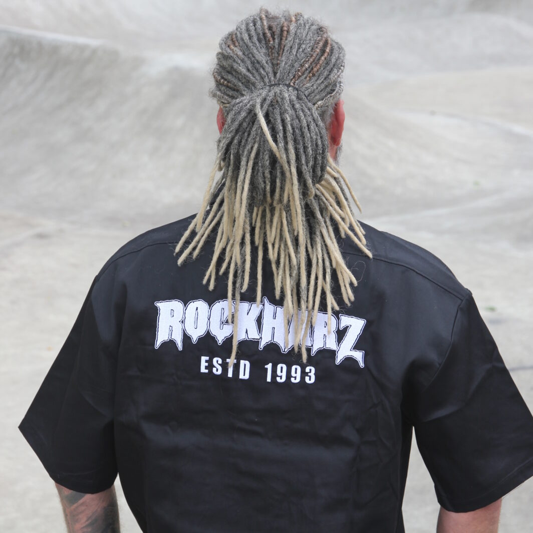 Schwarzes Kurzarm-Hemd auf dem Rücken mit großem Festival-Logo bestickt