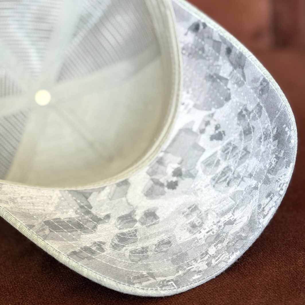 Bedruckte Schirm-Unterseite einer grauen Trucker Cap