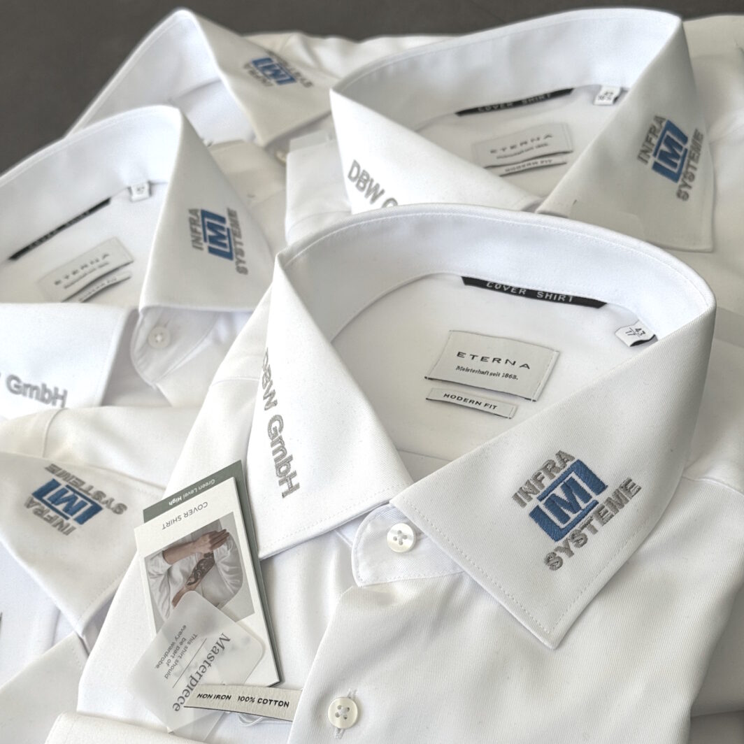 Weiße Hemden mit gestickten Logos am Kragen