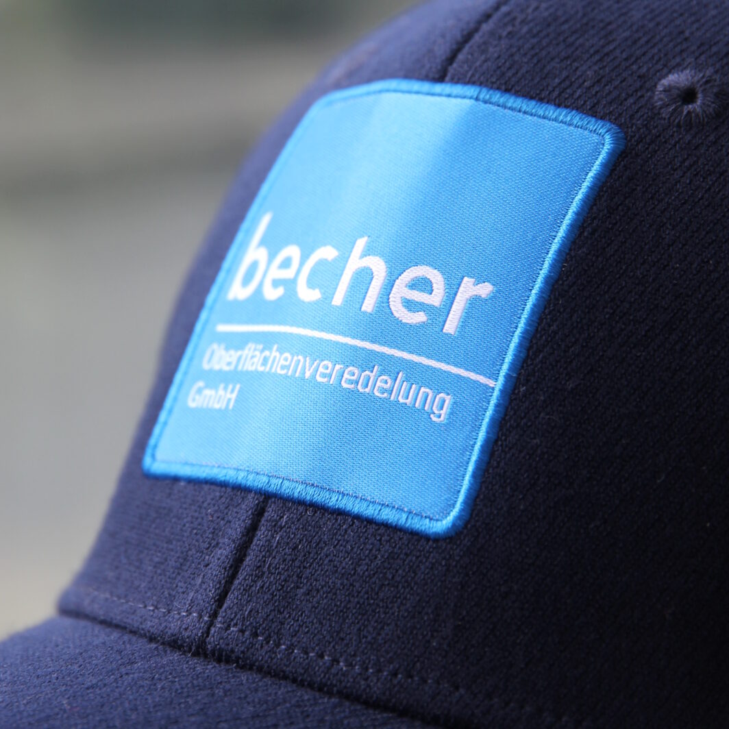 Dunkelblaue Cap mit Firmenlogo als hellblaues Web-Patch