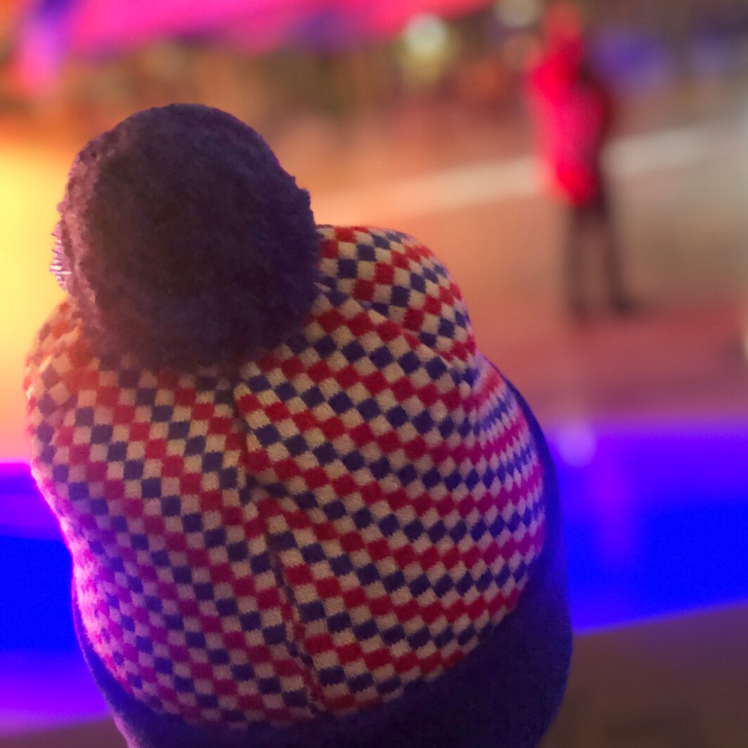 Fan-Mütze mit Karo-Muster und Bommel bei Eishockey-Spiel