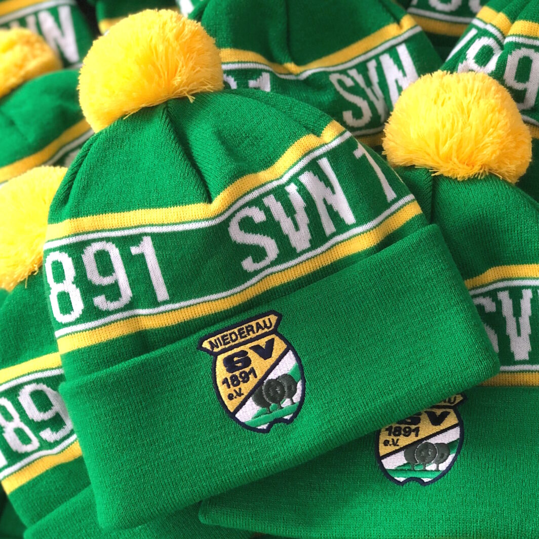 Grün-gelbe Mützen bestickt mit Sportverein-Logo