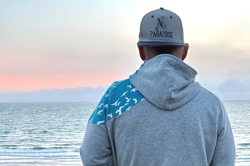 Mann am Meer mit bestickter Cap mit bedrucktem Schirm