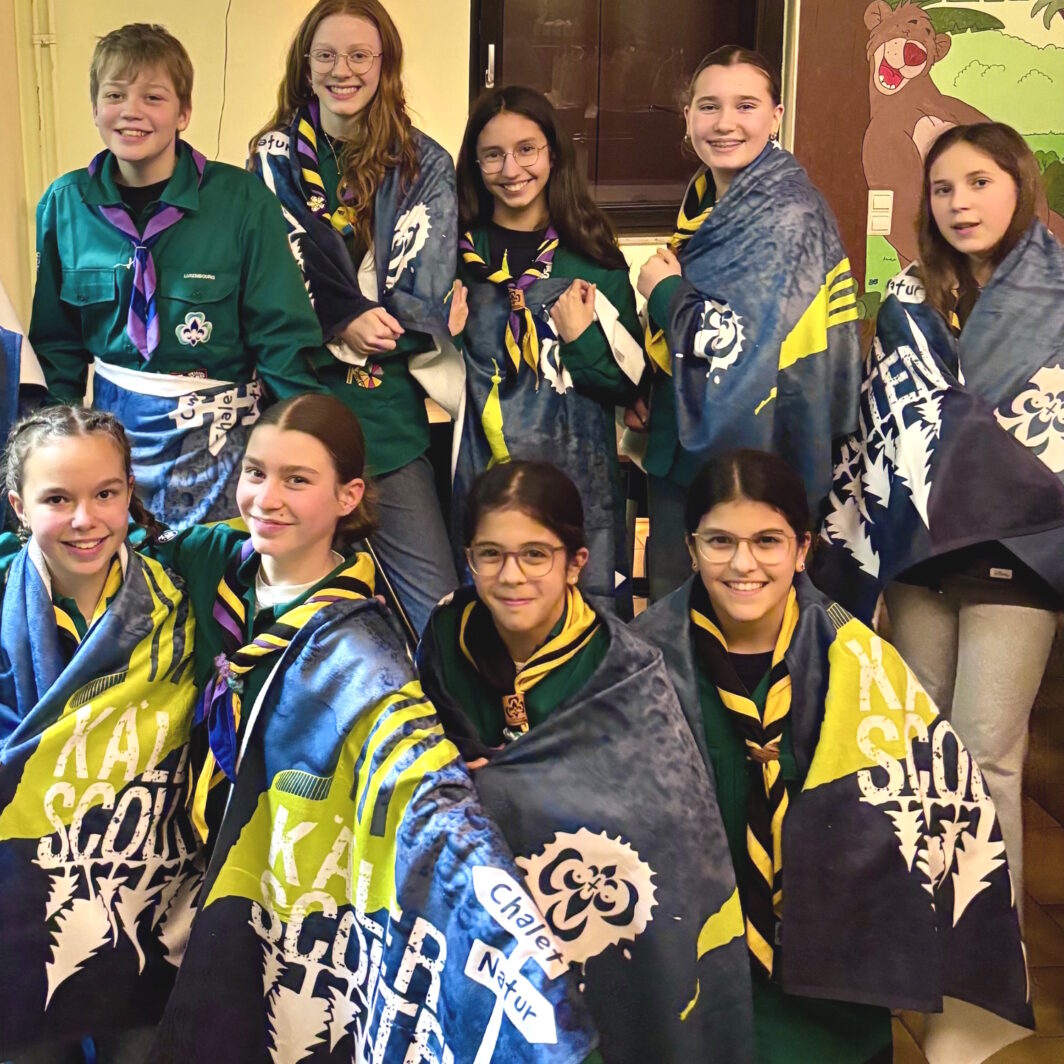 Kinder mit bedruckten Badetüchern im Design einer Pfadfindergruppe