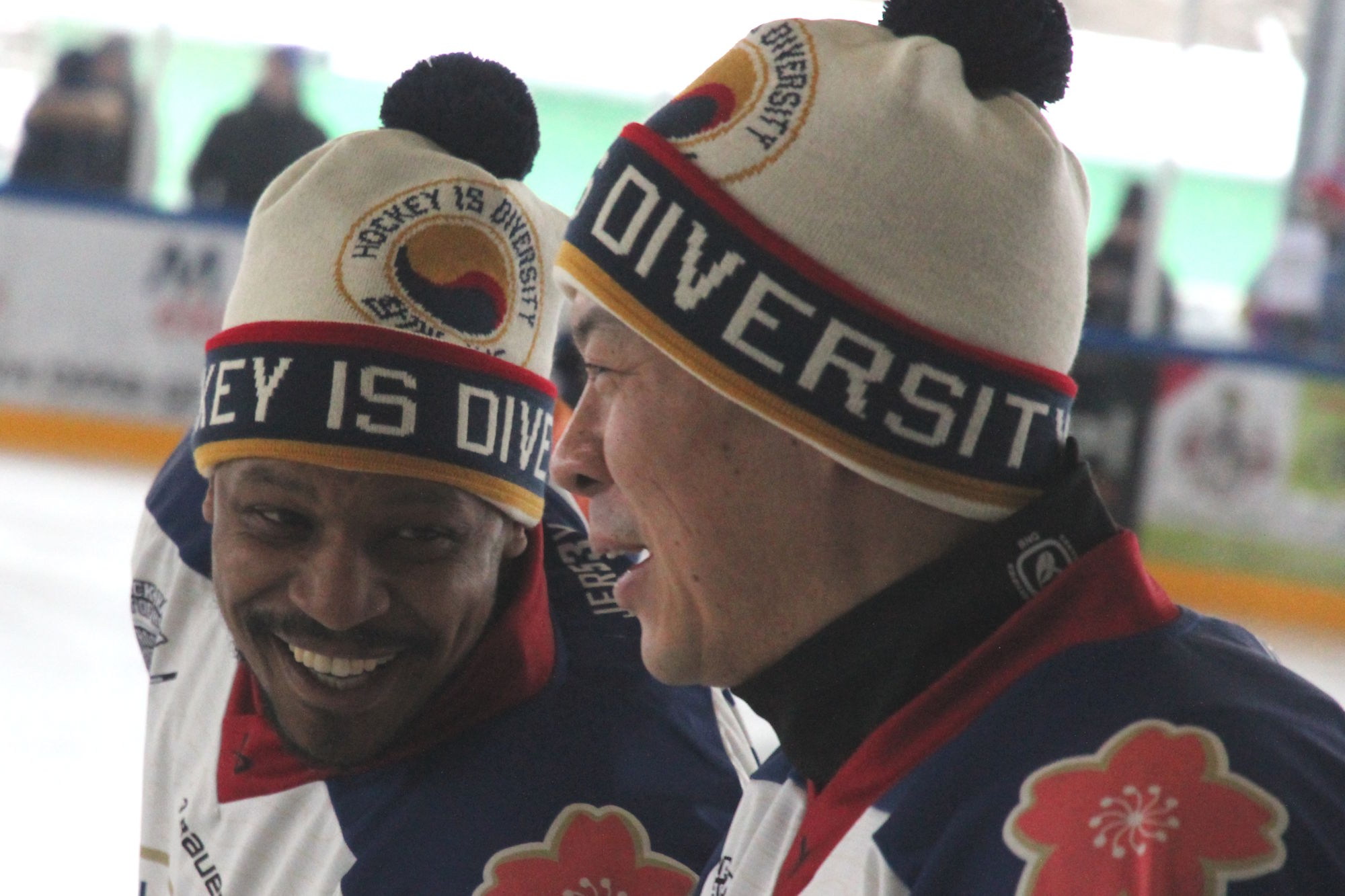 Zwei Eishockeyspieler mit Teammützen haben Spaß